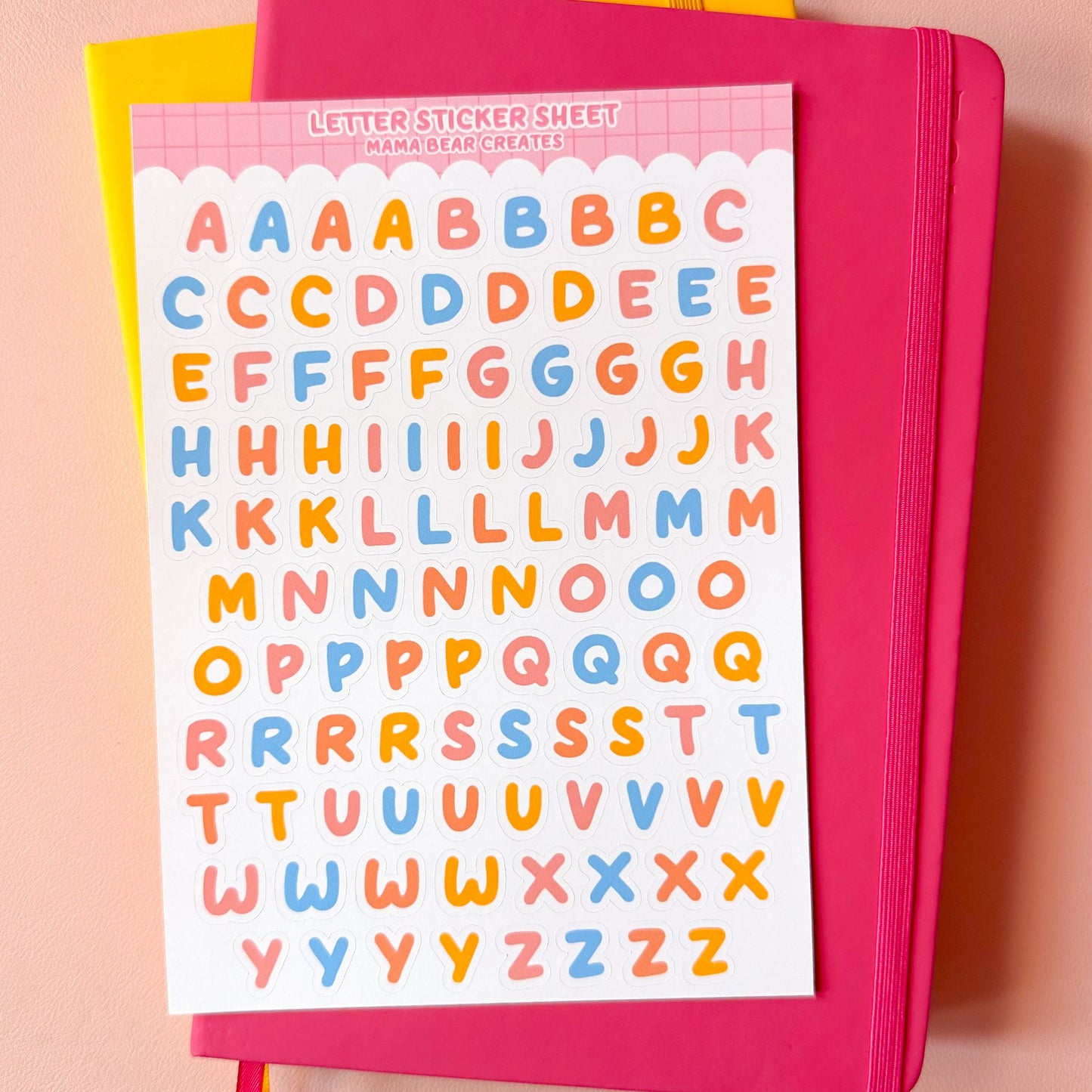 Pink notebook with letter stickers on a pink background