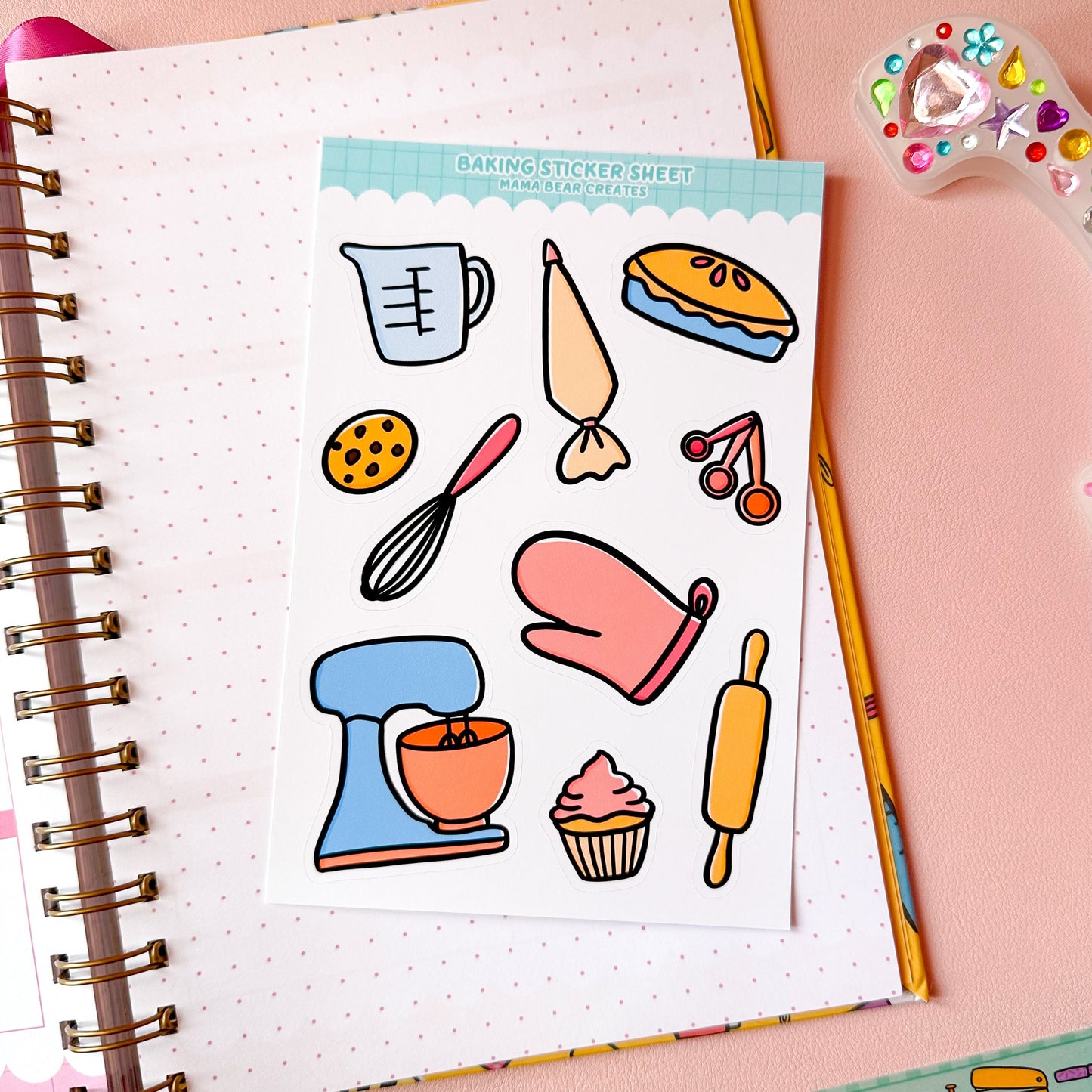 Sheet of baking-themed stickers on a notebook with colorful stationery items.