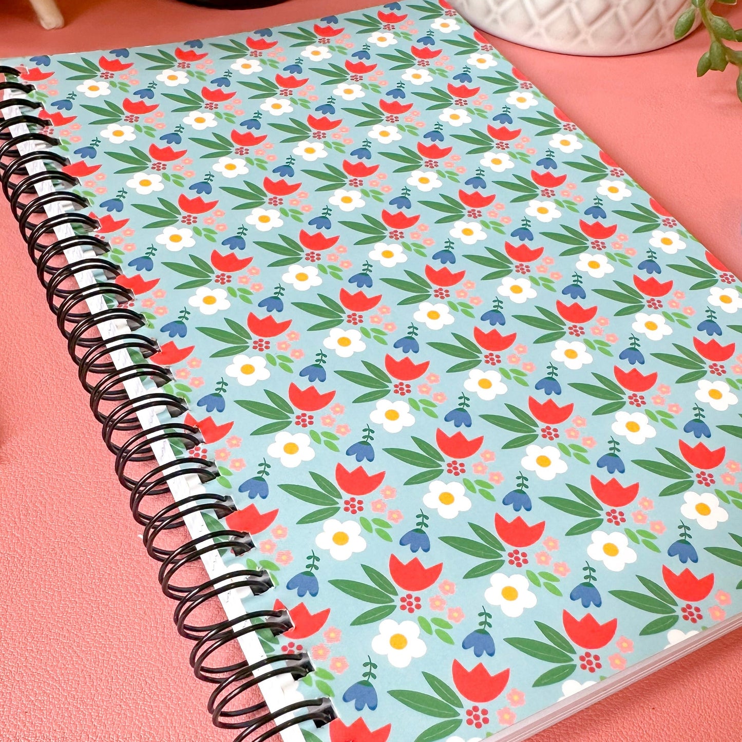 Notebook with floral pattern on a pink surface