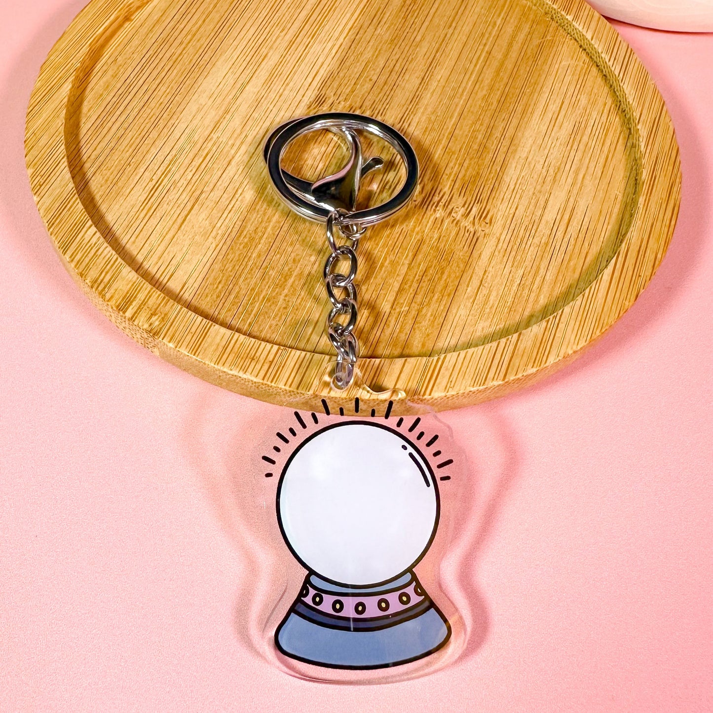 Keychain with a crystal ball design on a pink background