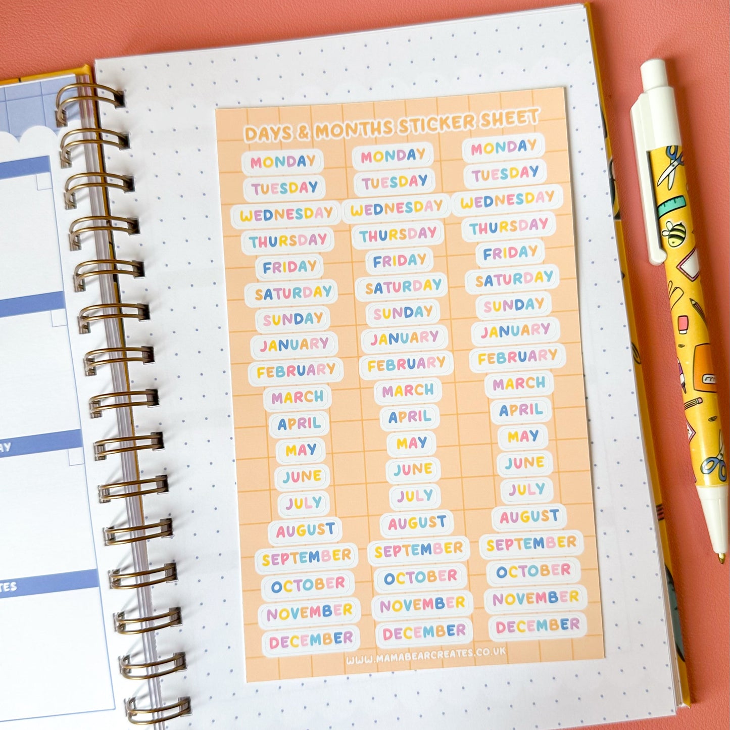 Colorful days and months sticker sheet on a planner with a pen on a pink background