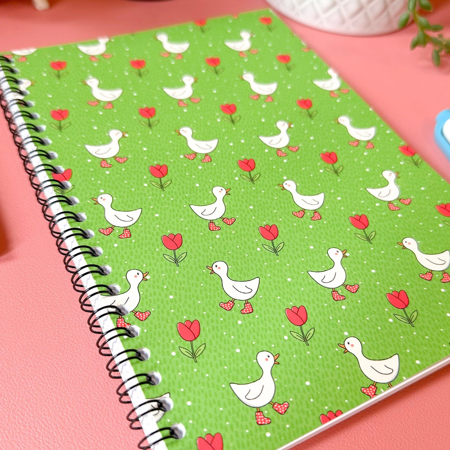 Notebook with duck and heart pattern on a pink surface