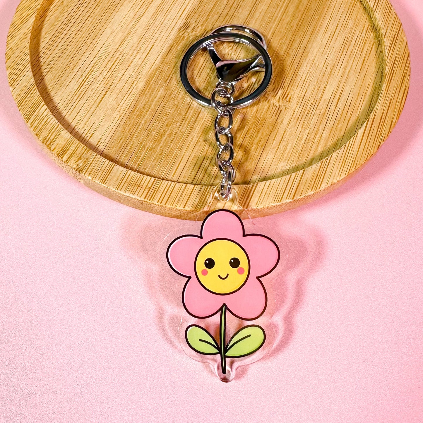 Keychain with a cartoon flower design on a pink background