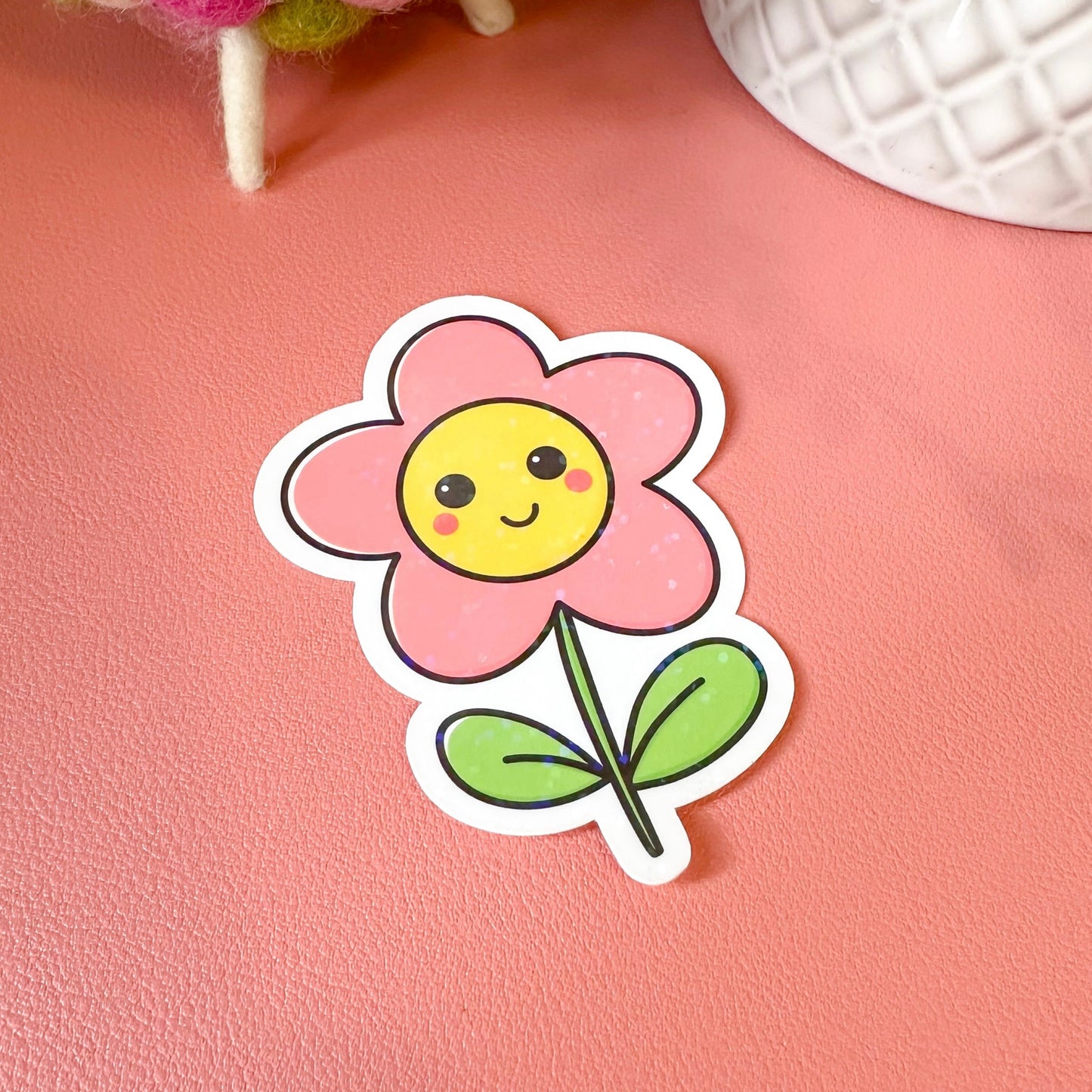 Cartoon flower sticker with a smiley face on a pink surface