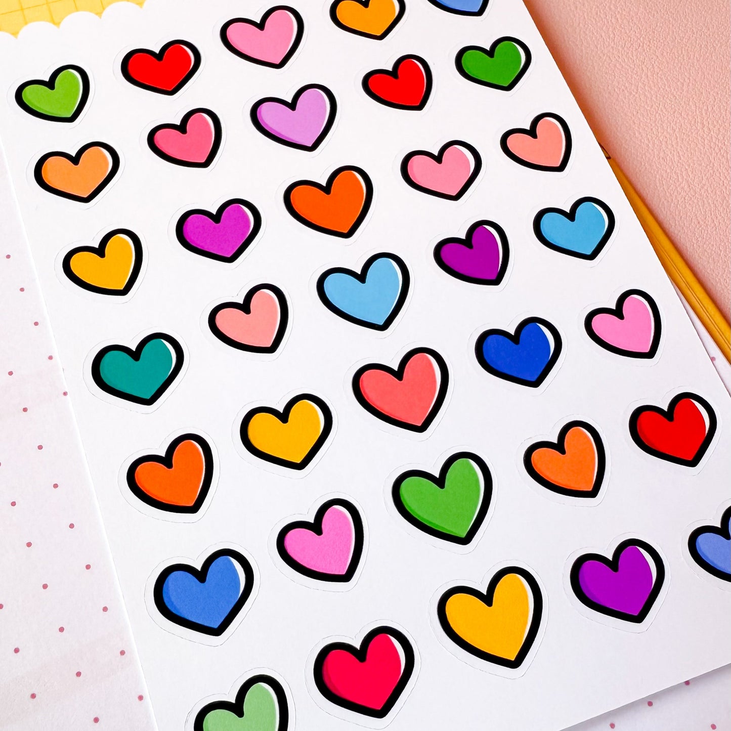 Sheet of colorful heart-shaped stickers on a white background