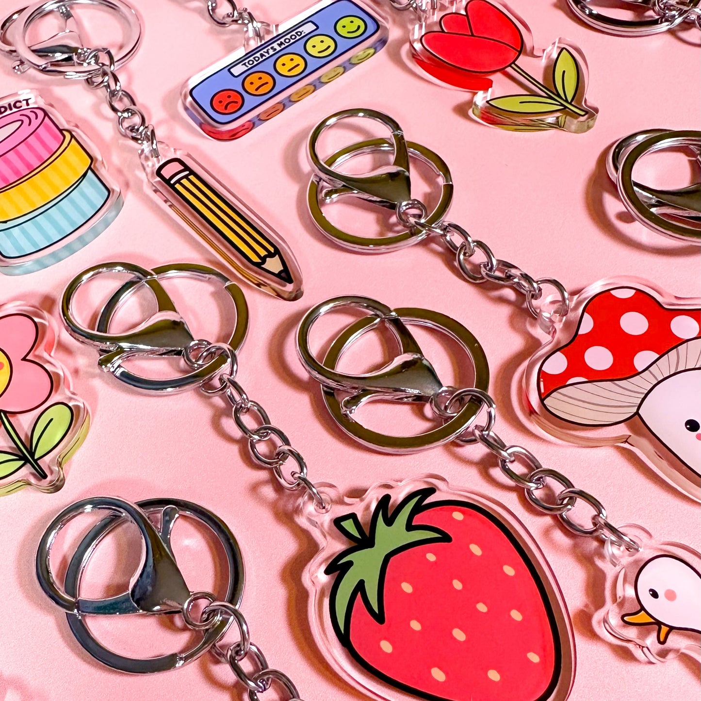 Collection of colorful keychains on a pink background