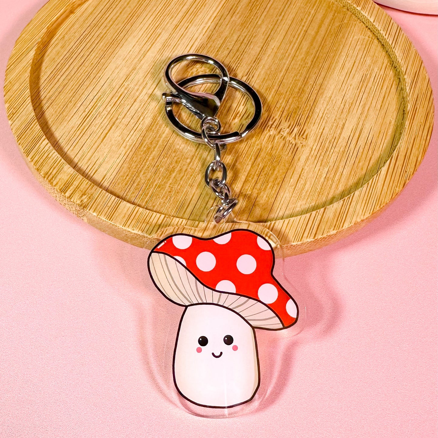 Keychain with a cartoon mushroom design on a pink background