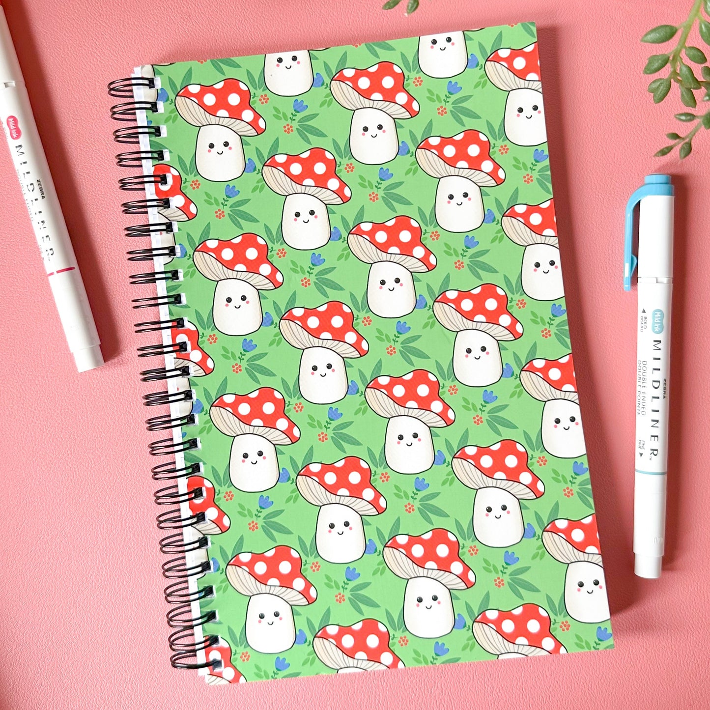 Notebook with ghost and mushroom pattern on a pink background