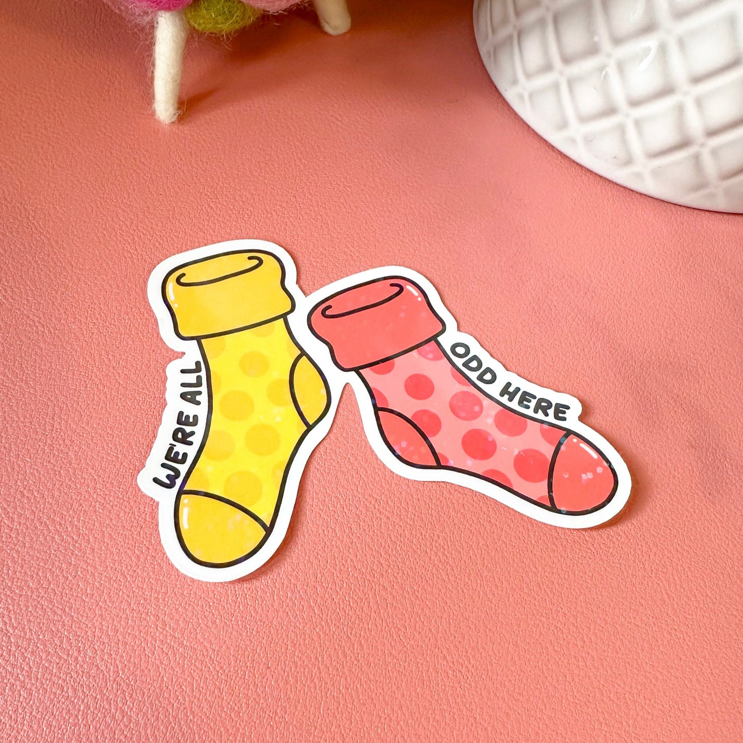 Two colorful sock-shaped stickers on a pink surface