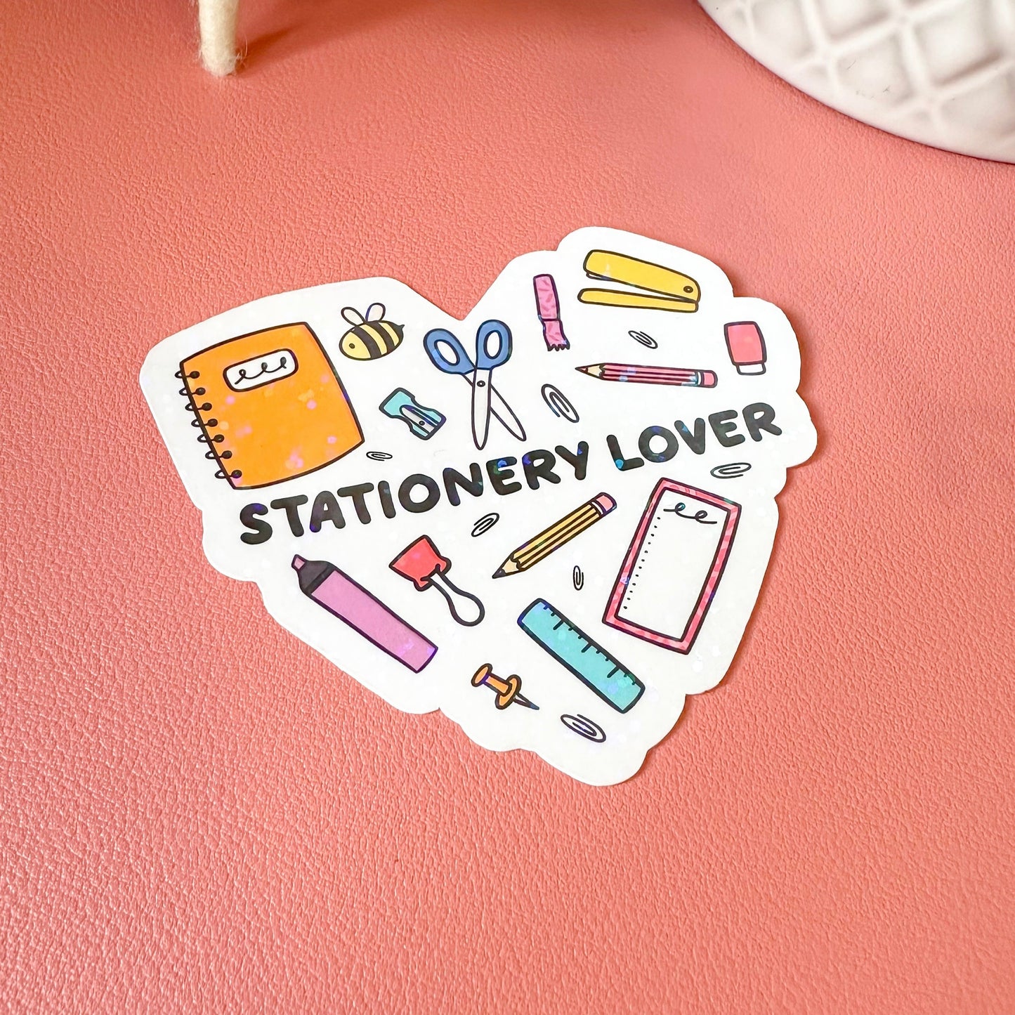 Sticker with stationery icons and 'Stationery Lover' text on a pink surface