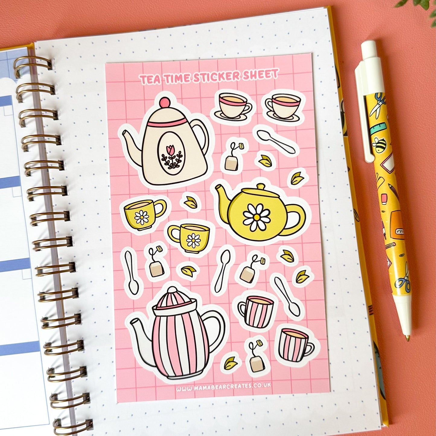 Tea-themed sticker sheet on a notebook with a pen on a pink background