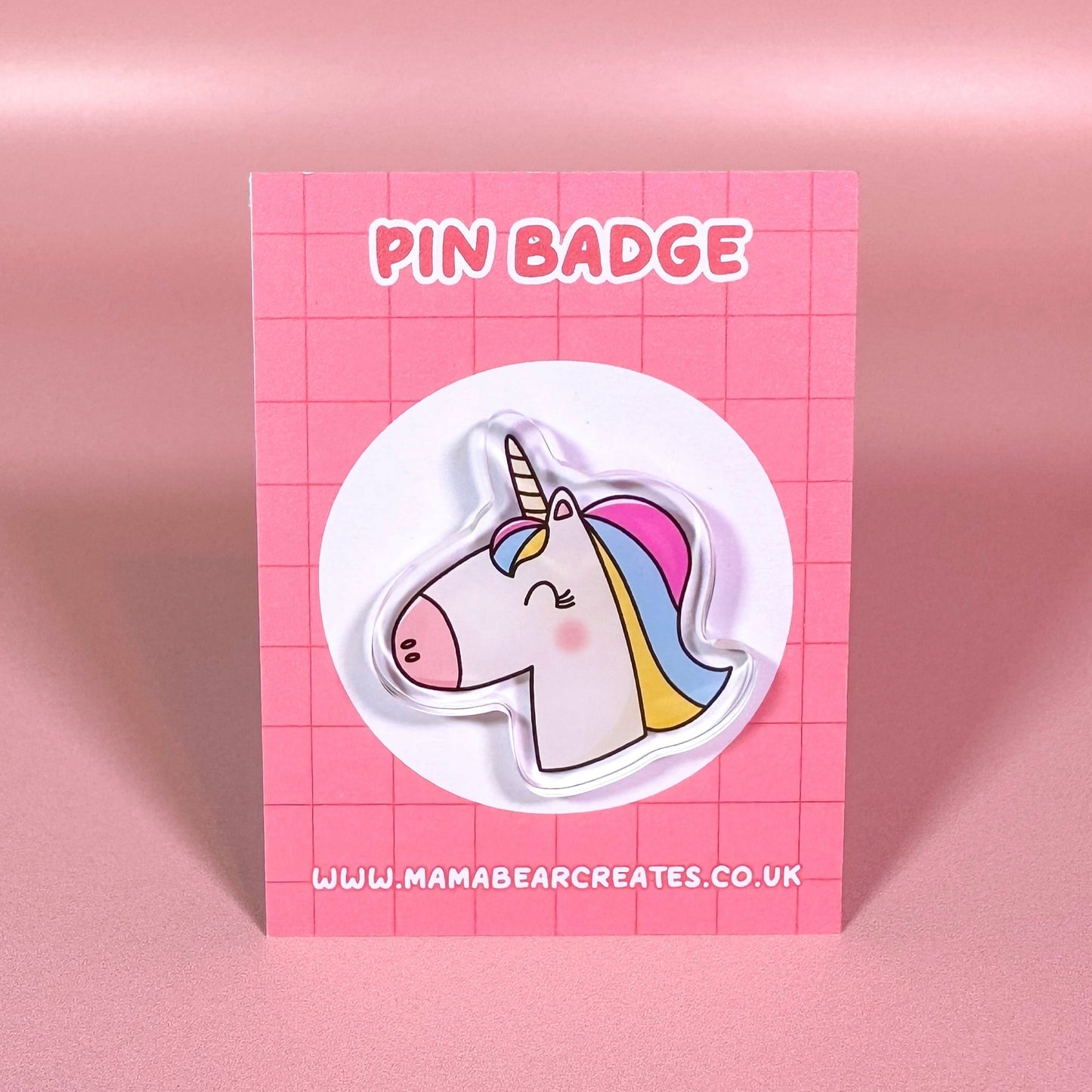 Pin badge of a unicorn on a pink card with 'Mama Bear Creates' branding.