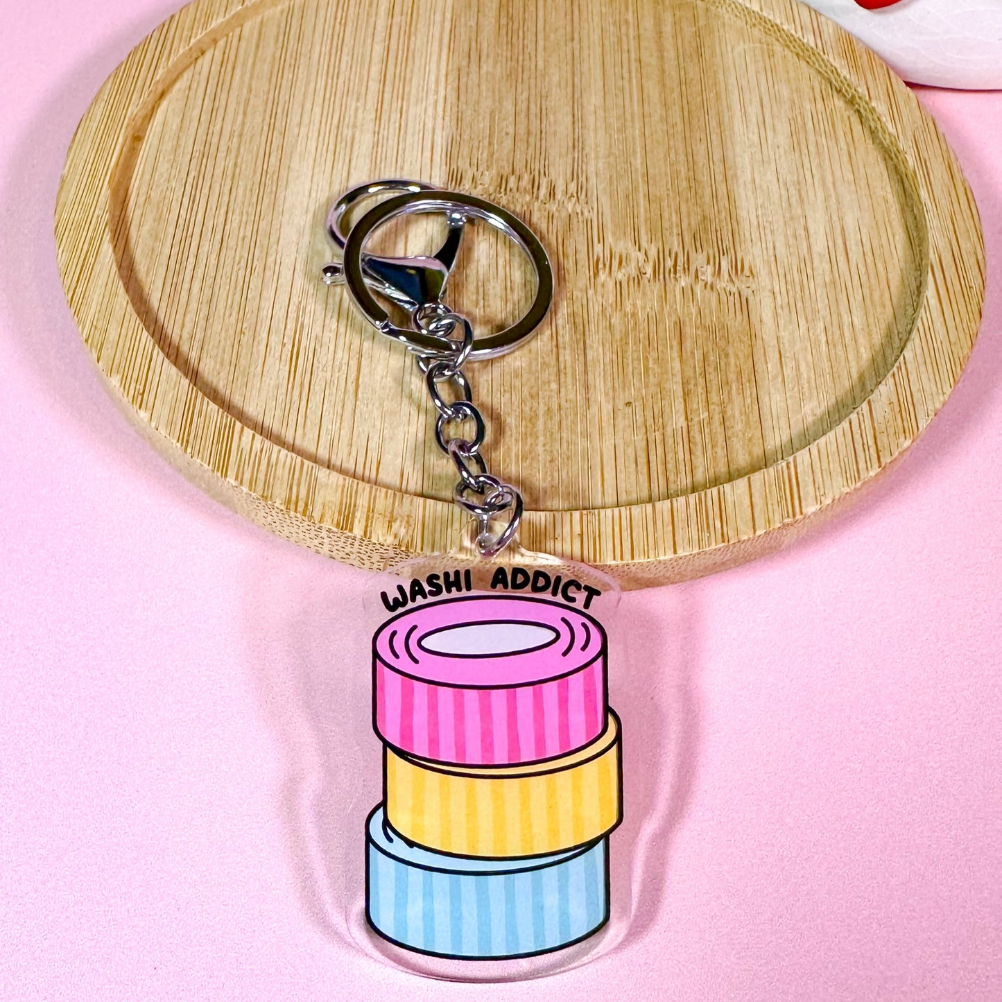 Keychain with colorful washi tape design on a pink background