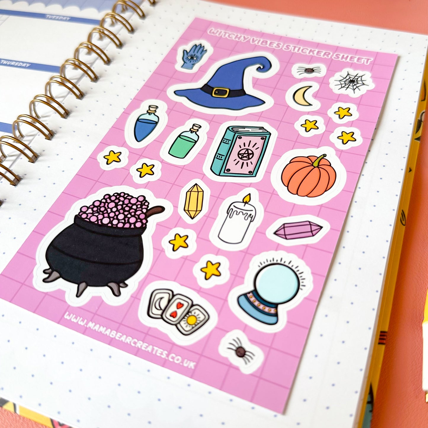 Halloween-themed sticker sheet on a notebook with a pink border