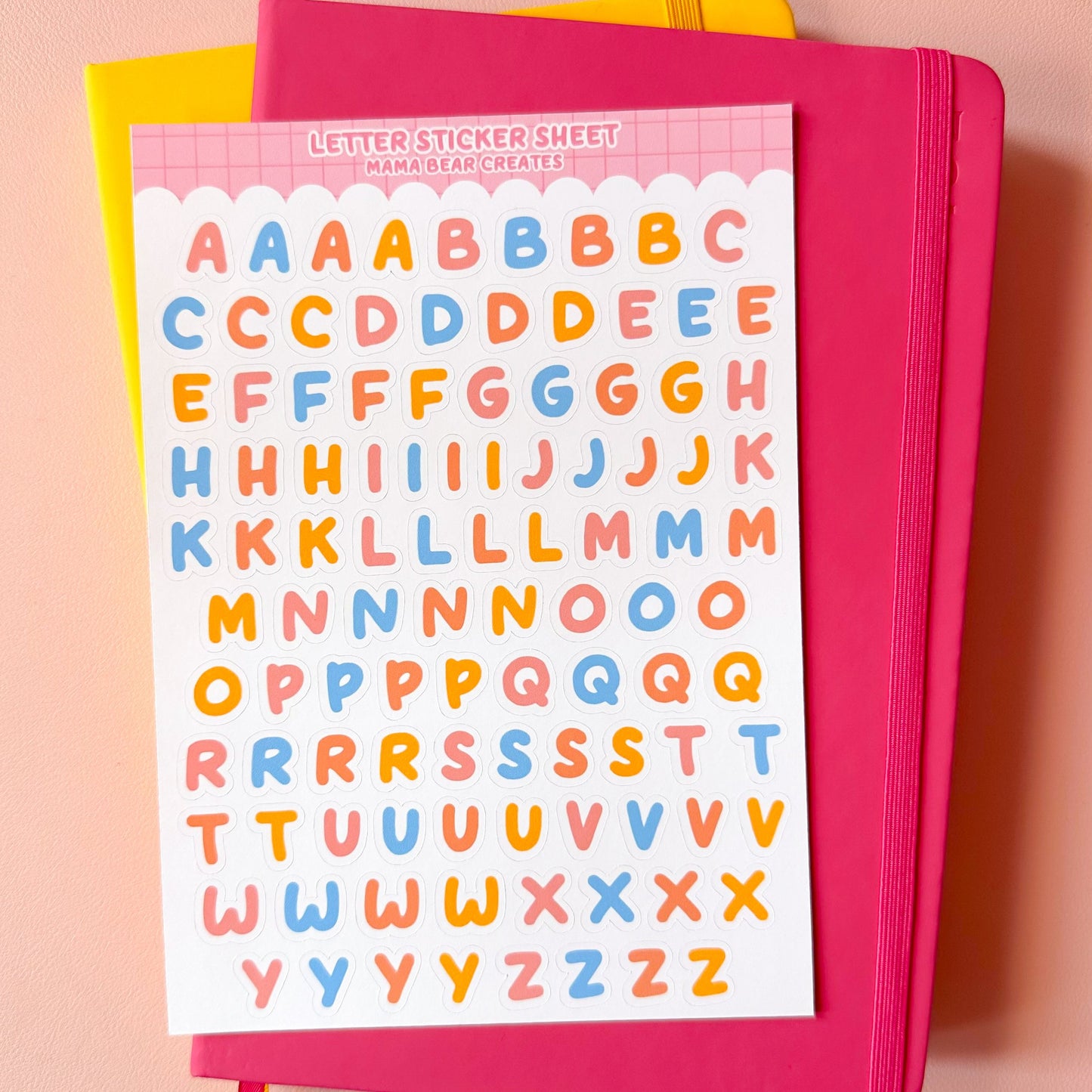 Pink notebook with letter stickers on a pink background
