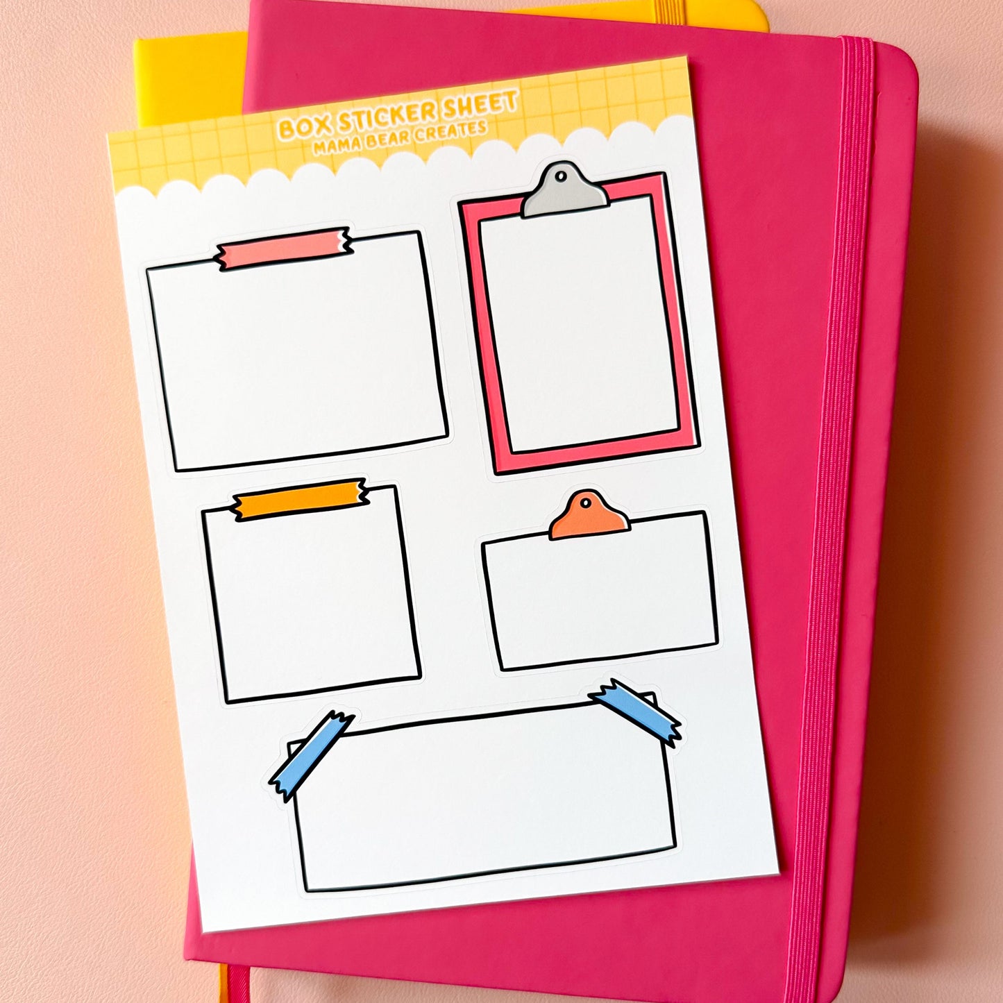 Colorful stationery items including a pink notebook and a sheet of clipart on a pink background