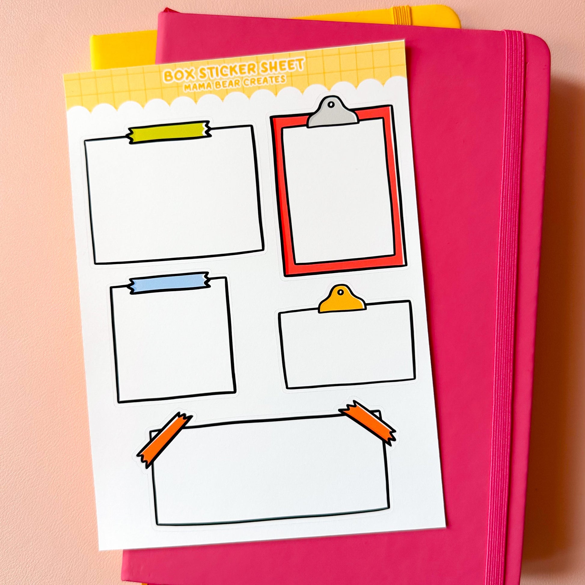Pink notebook with a sheet of clipart-style frames on a pink background