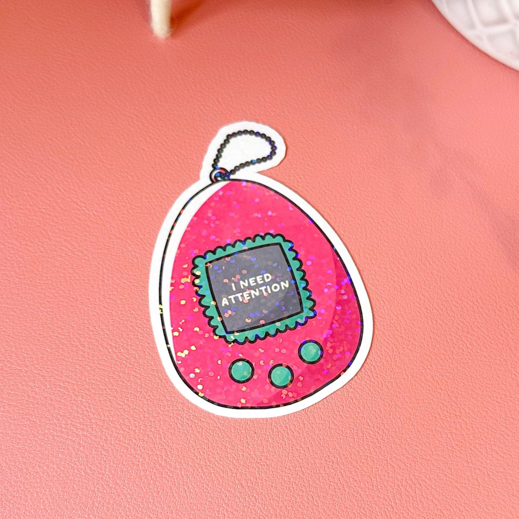 Pink toy with 'I need attention' text on a pink background