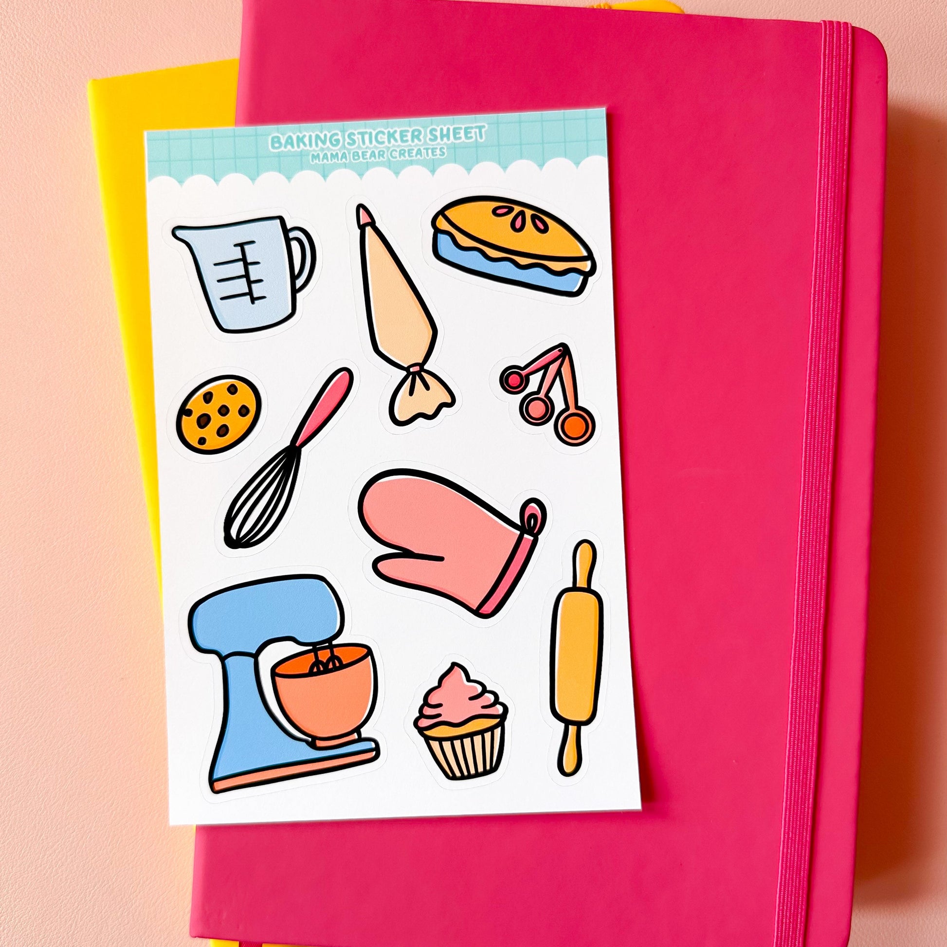 Pink notebook with a baking-themed sticker sheet on a pink background