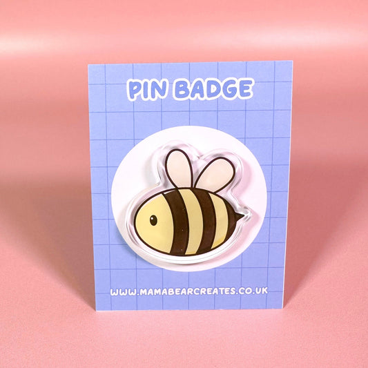 Bee pin badge on a blue card with 'MamaBearCreates' branding against a pink background