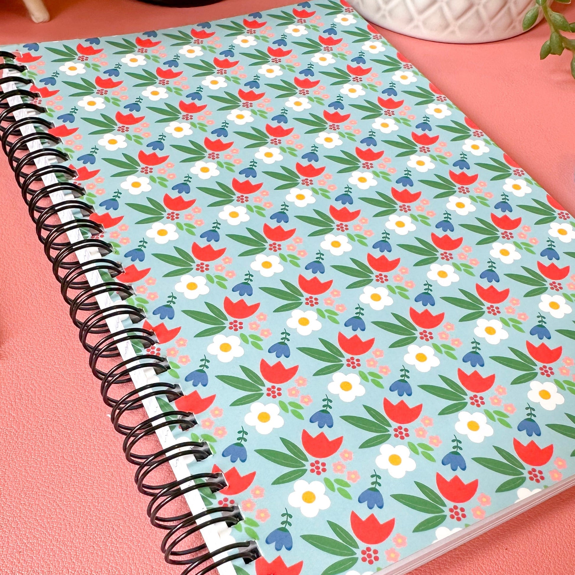 Notebook with floral pattern on a pink surface
