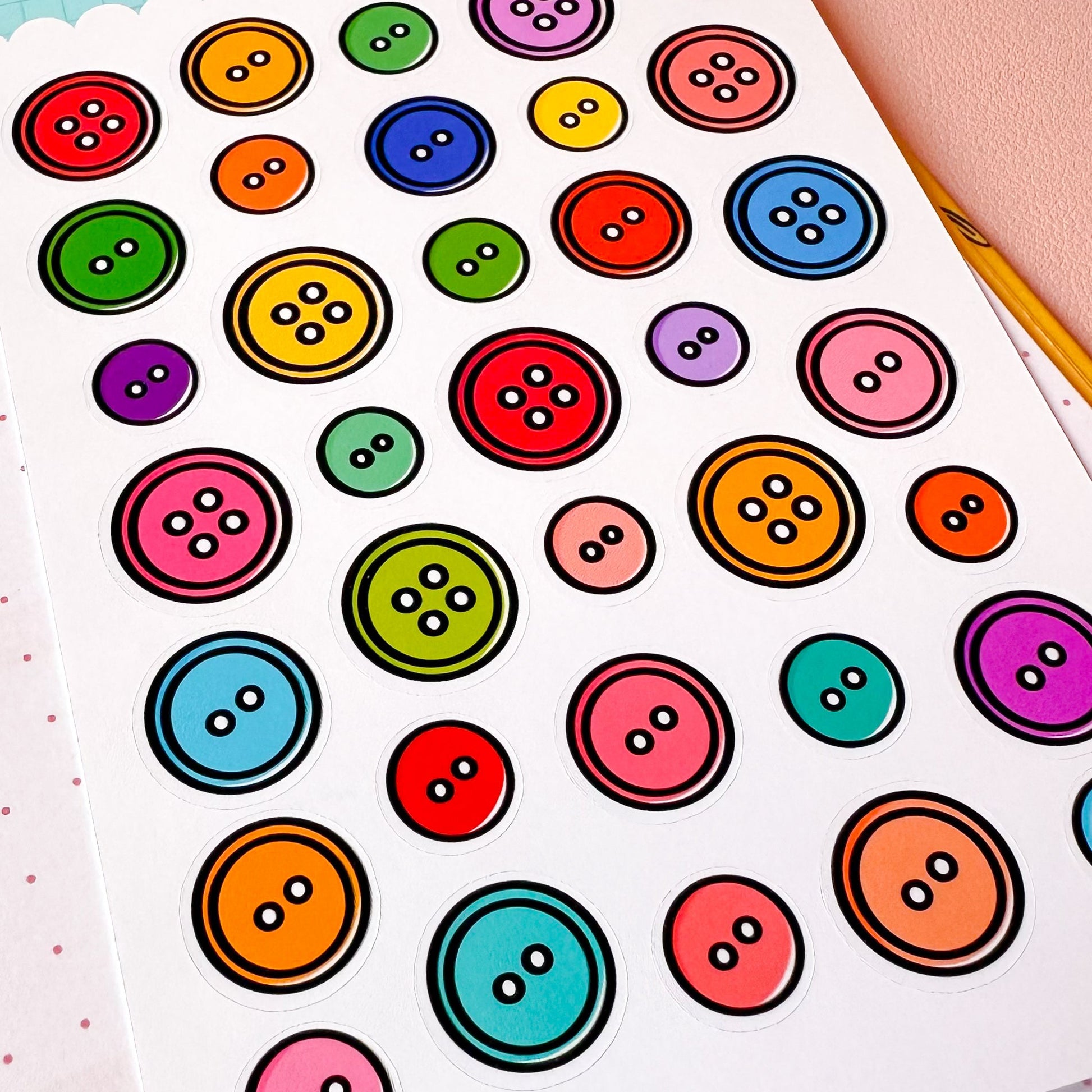 Sheet of colorful button-shaped stickers on a light blue background