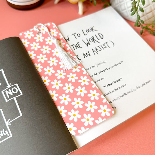 Floral bookmark on a book with a pink background