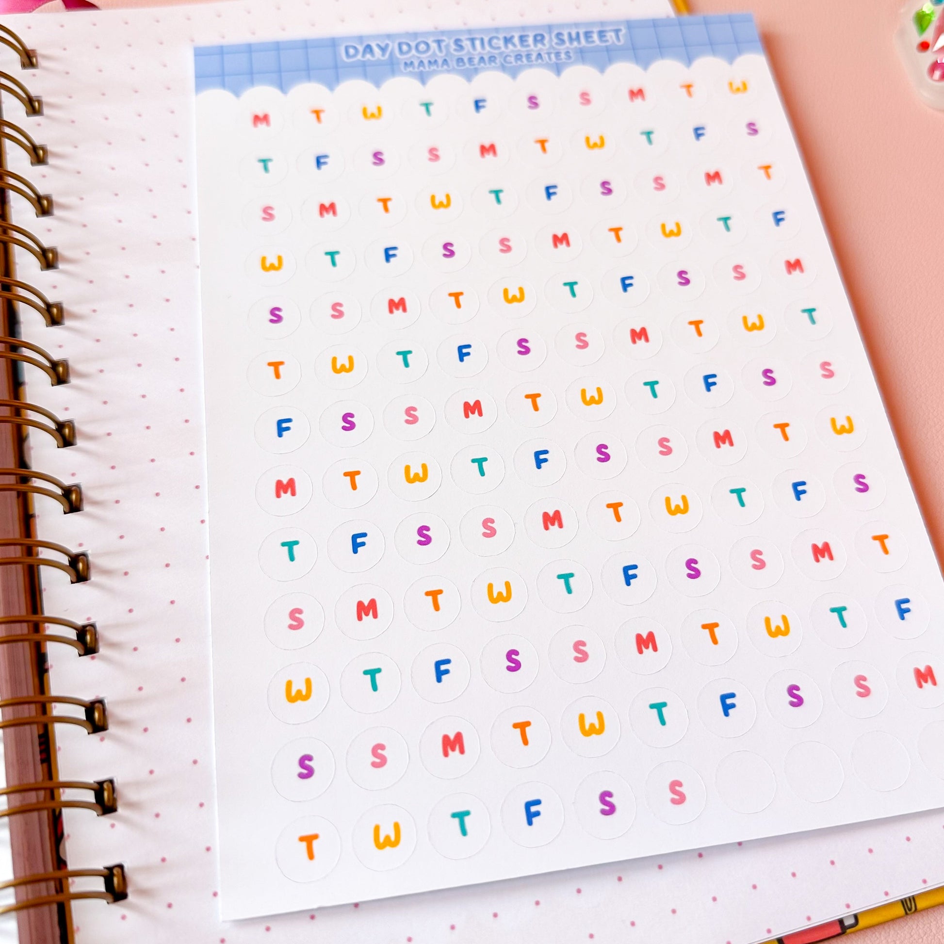 Colorful letter stickers on a planner sheet with stationery items around
