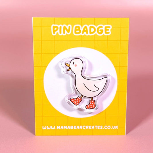 Pin badge packaging with a duck design on a yellow background