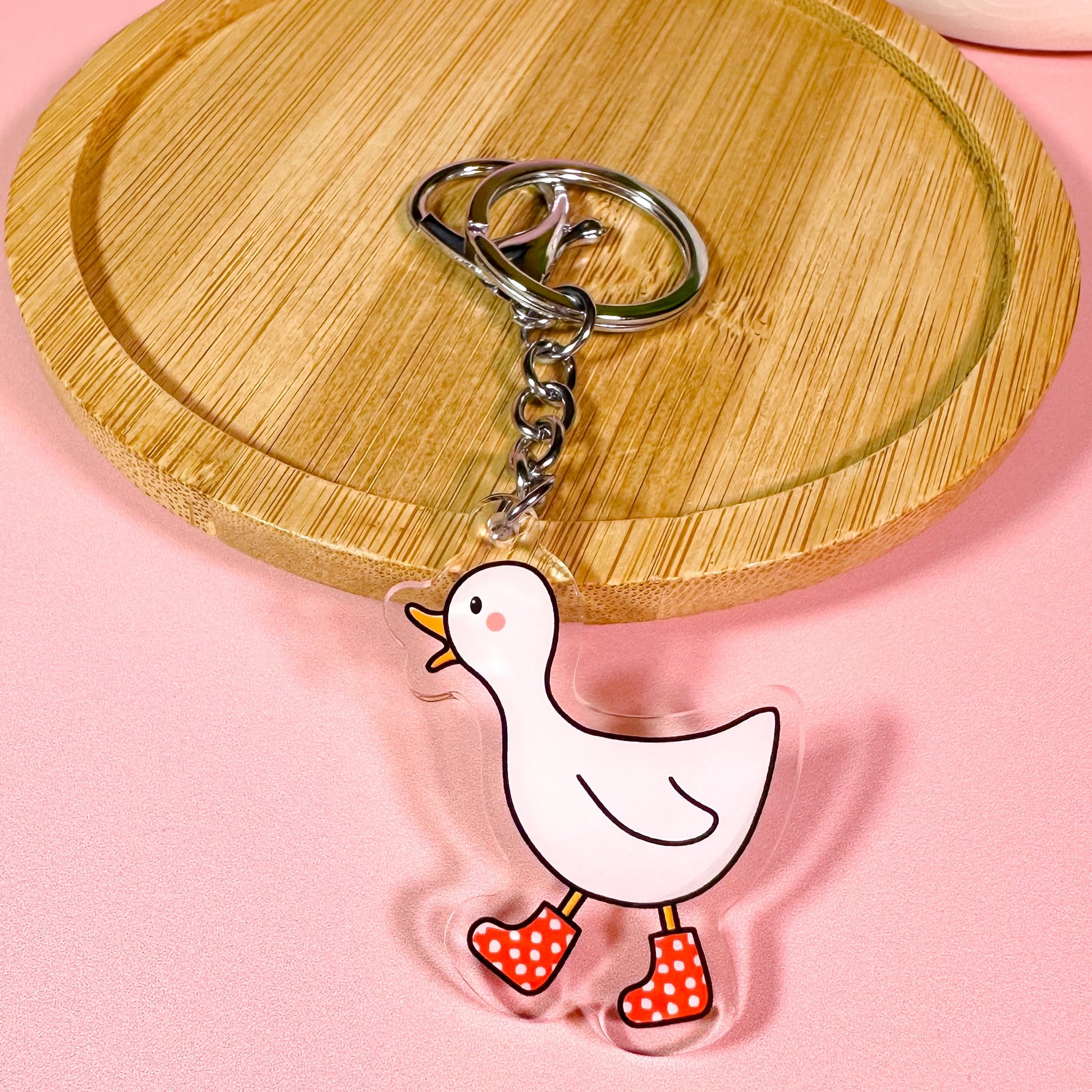 Keychain with a cartoon duck design on a pink background