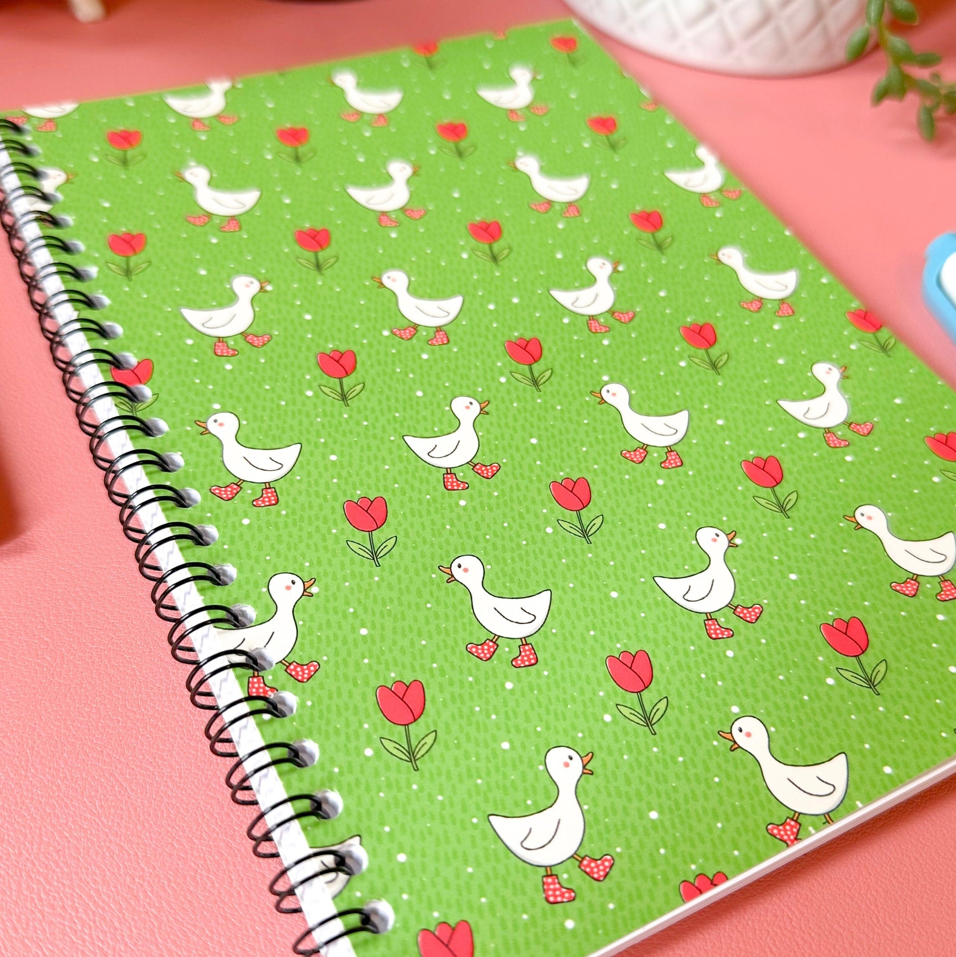 Notebook with duck and heart pattern on a pink surface