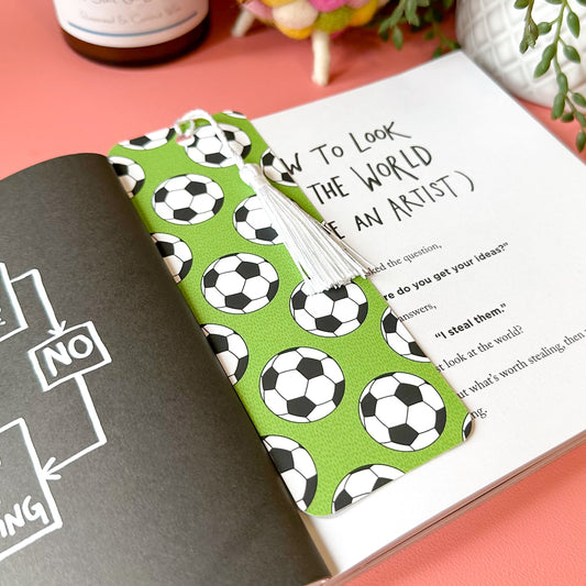Book with a football patterned bookmark on a pink surface