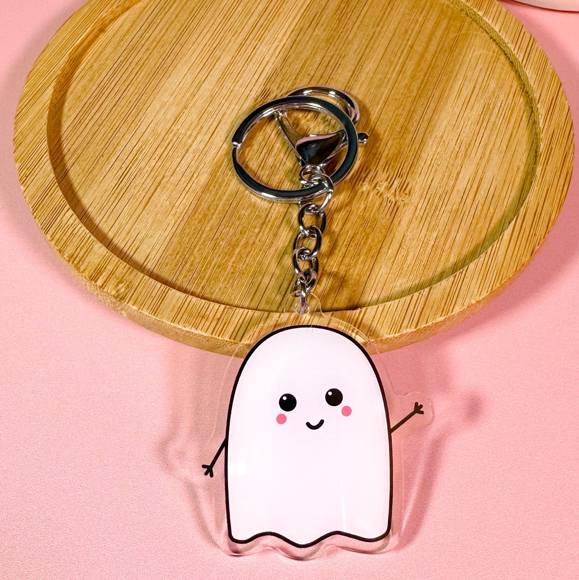 Keychain shaped like a cartoon ghost on a pink background