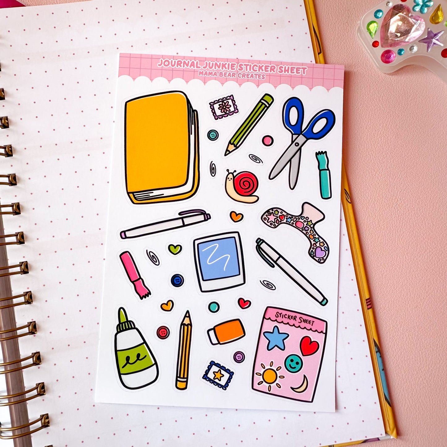 Sticker sheet with stationery items on a notebook with stationery on a pink background
