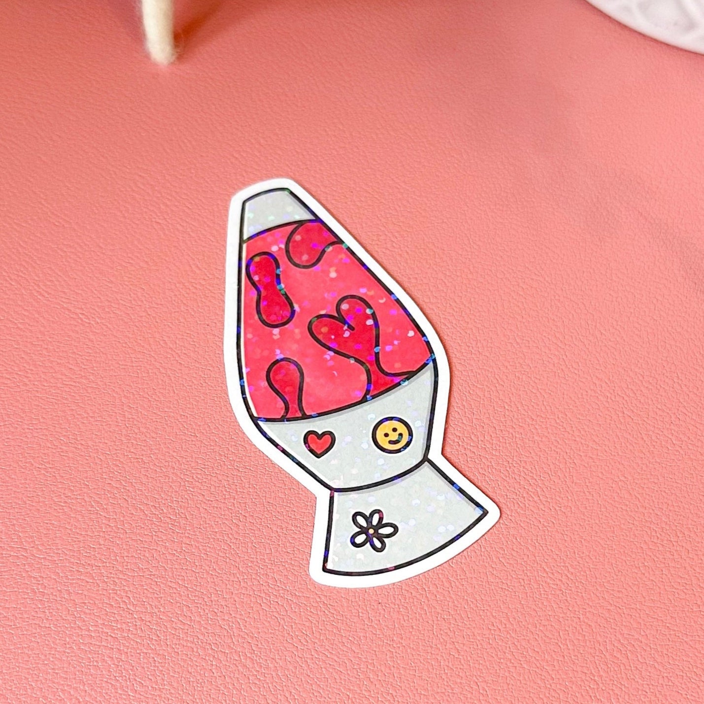 Sticker of a colorful lava lamp with hearts on a pink surface