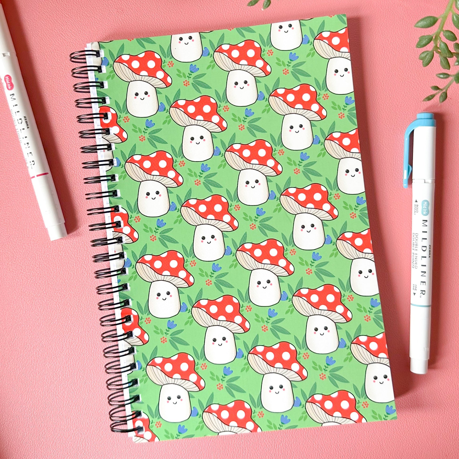 Notebook with ghost and mushroom pattern on a pink background