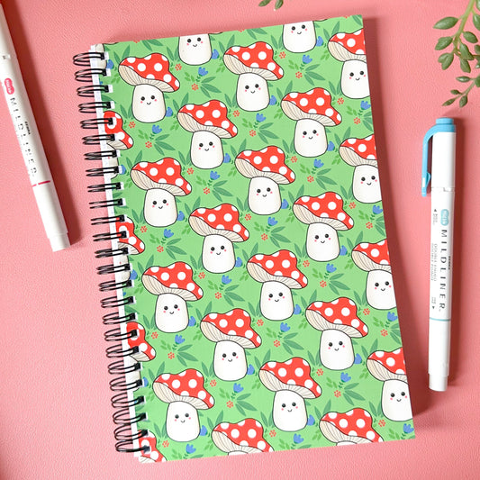 Notebook with ghost and mushroom pattern on a pink background