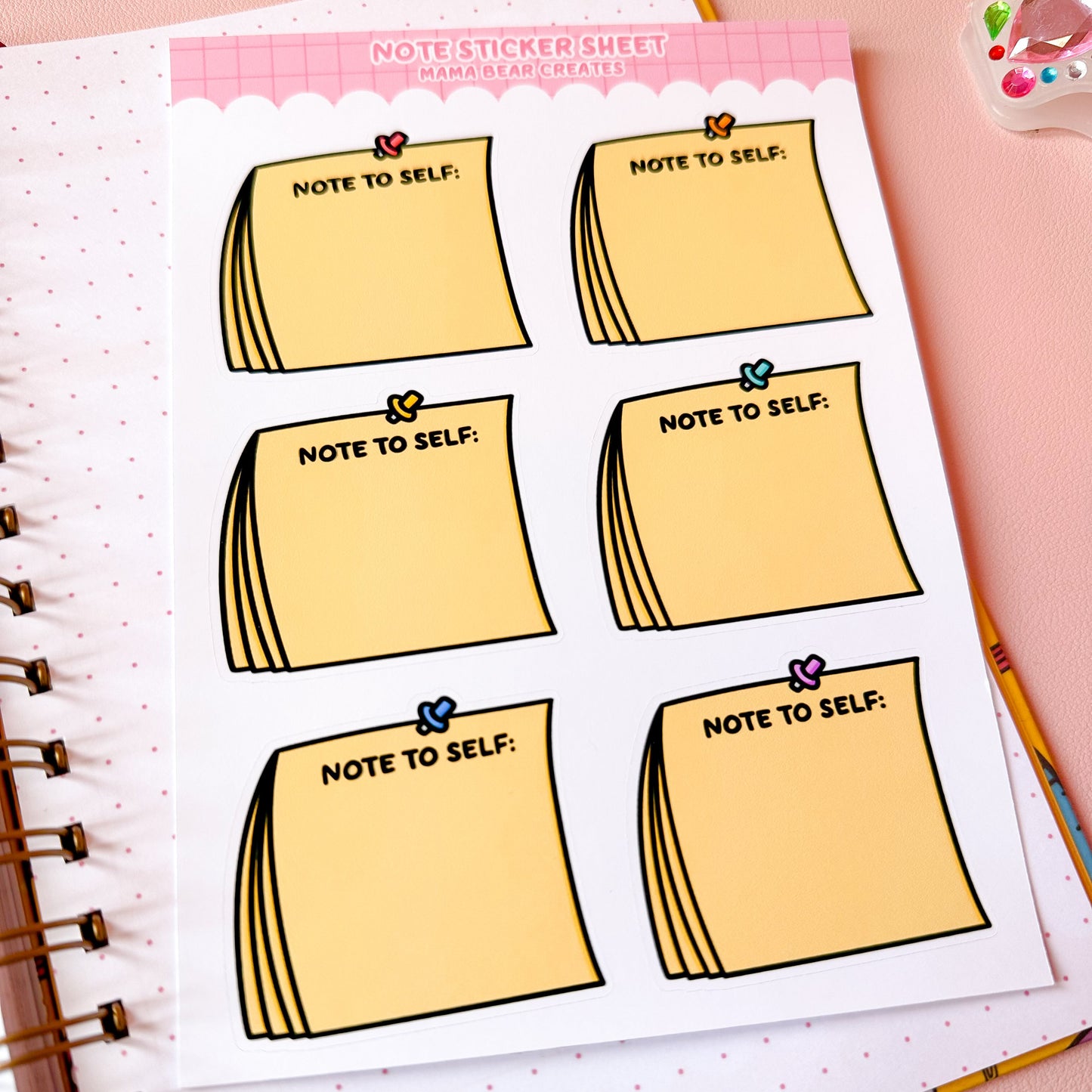 Sheet of 'Note to Self' stickers on a notebook with stationery items around.