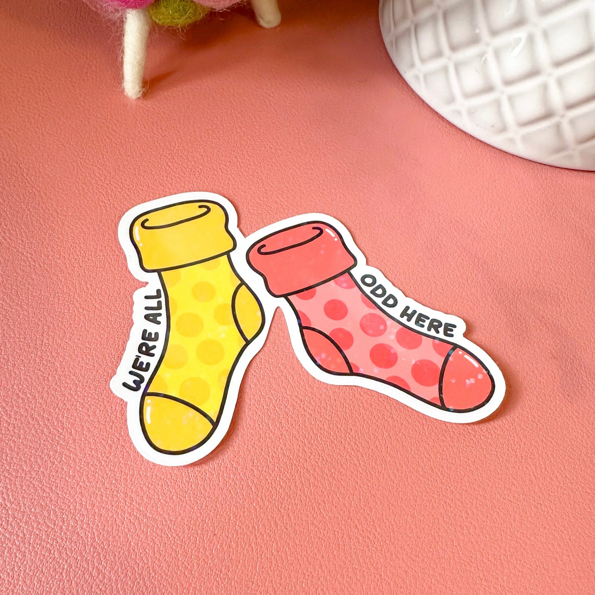 Two colorful sock-shaped stickers on a pink surface
