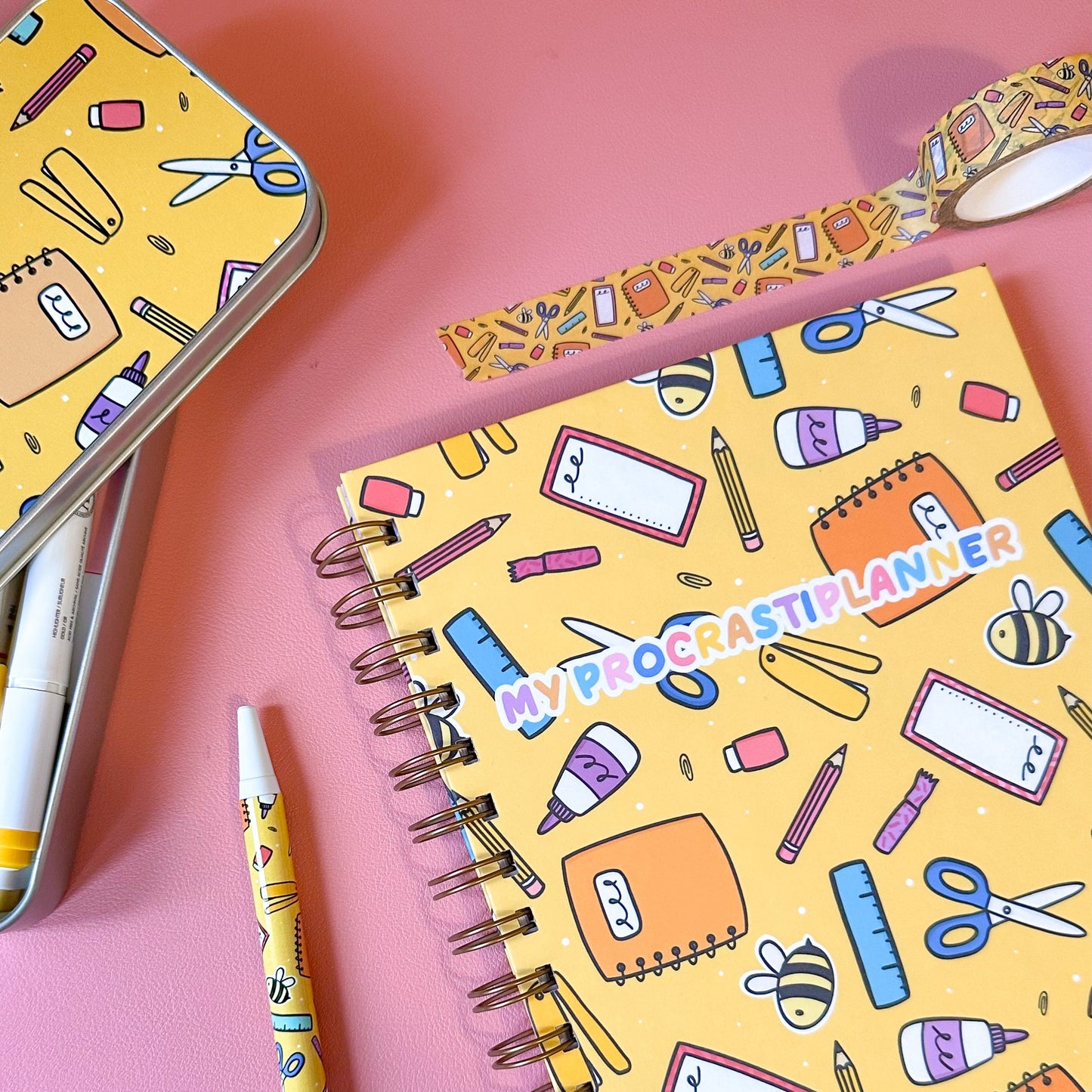 Notebook with stationery-themed cover on a pink background