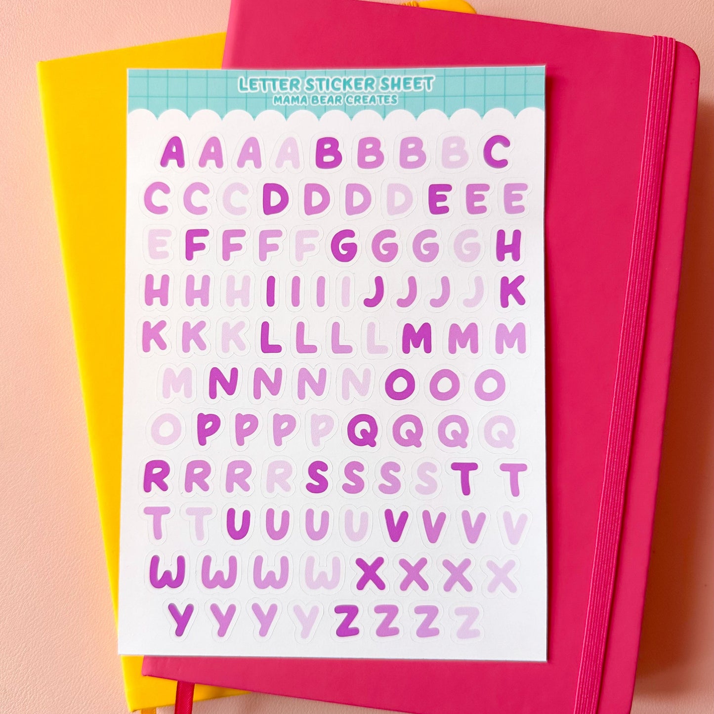 Letter sticker sheet with colorful letters on a pink notebook