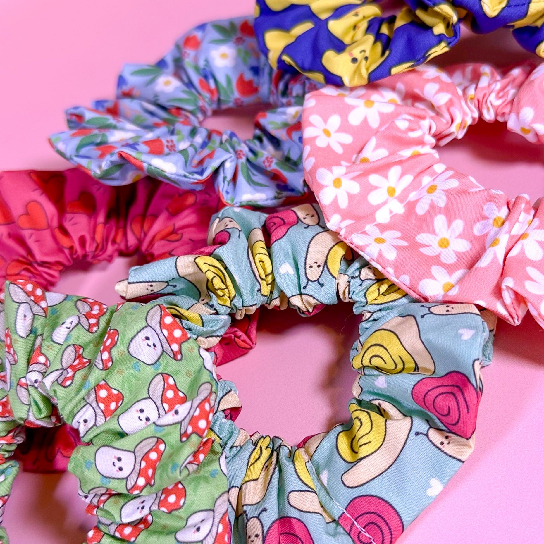 Colorful scrunchies with various patterns on a pink background