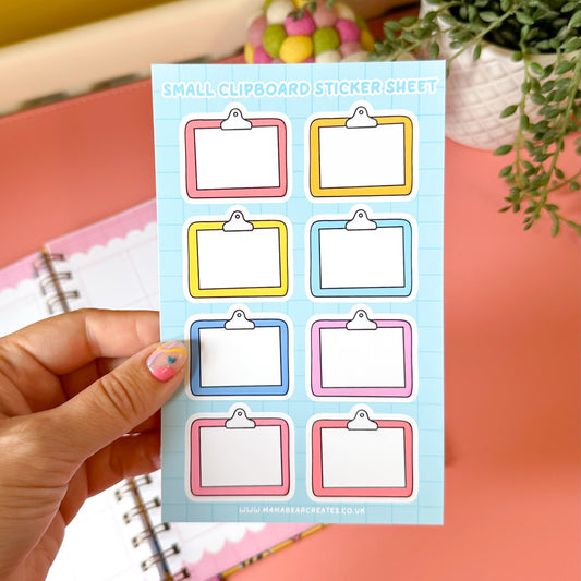 Sheet of small clipboard stickers held by a hand with a colorful background