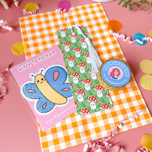 Vinyl sticker with butterfly design on pink card, green patterned paper, and circular sticker on orange checkered cloth.