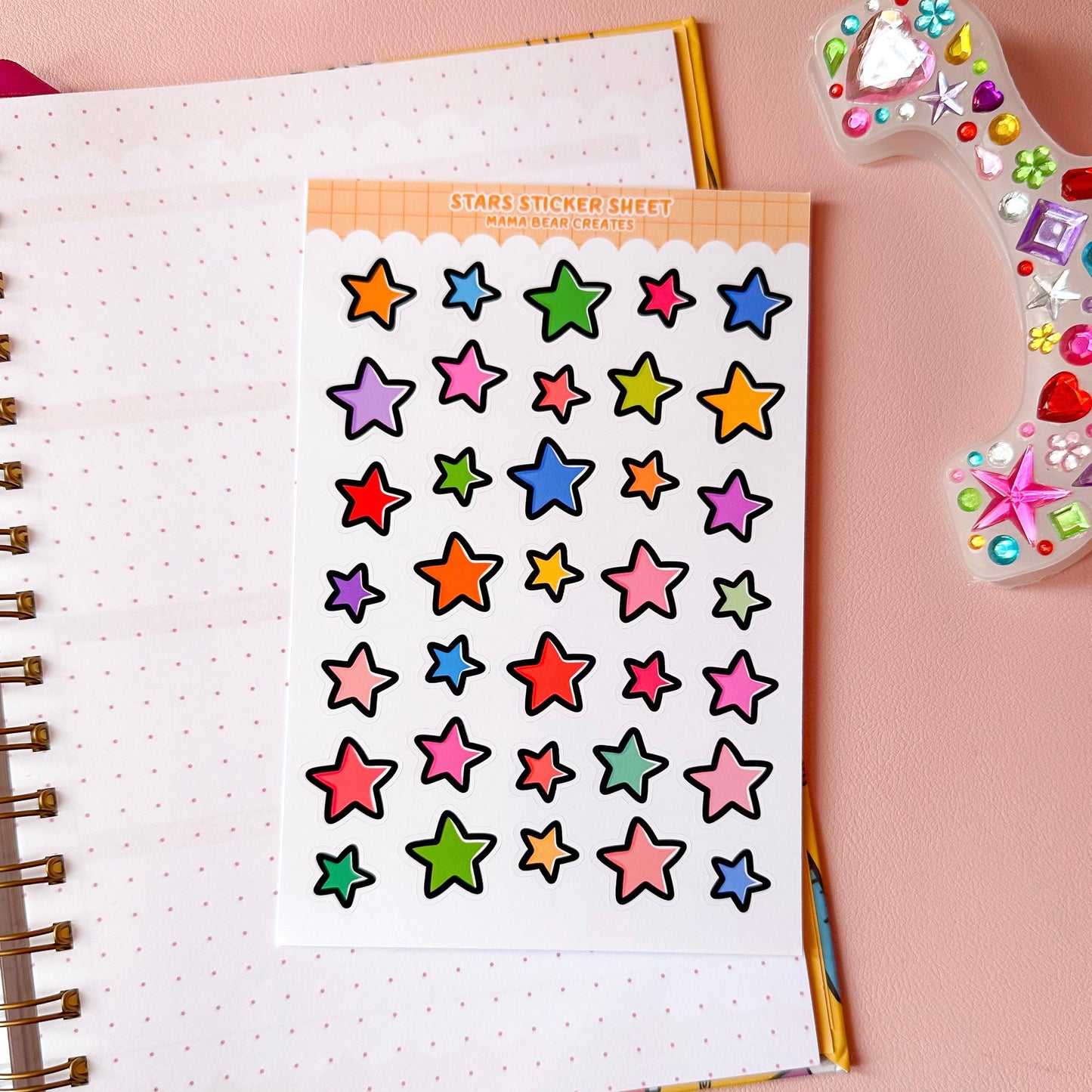Colorful star stickers on a notebook page with a pink background