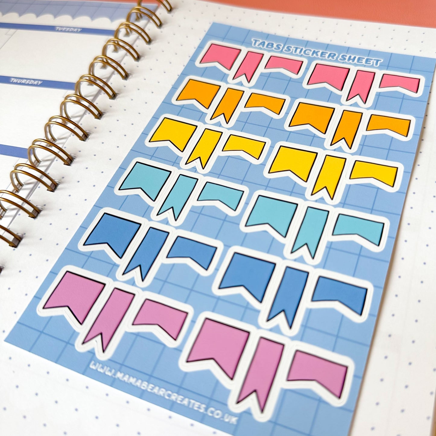 Sheet of colorful banner-shaped stickers on a planner page.