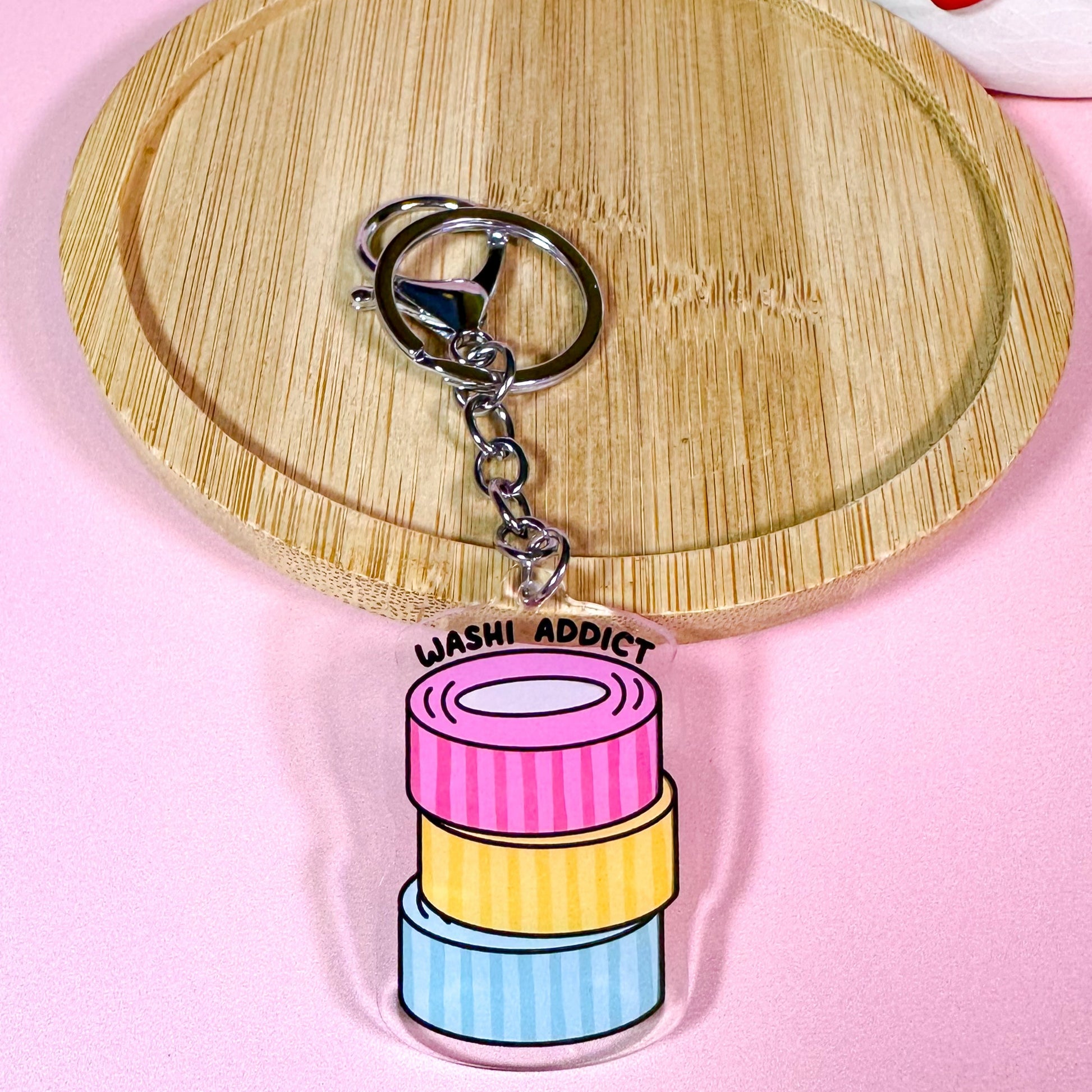 Keychain with colorful washi tape design on a pink background