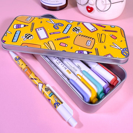 Colorful stationery items in a tin with pens and markers on a pink background